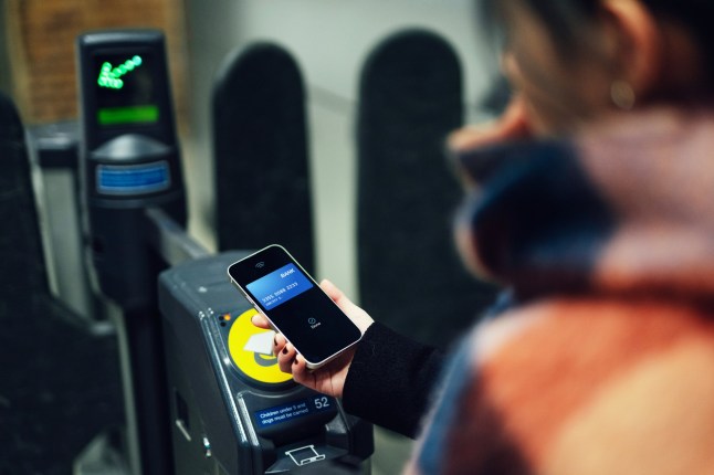 Young woman checking in at subway station with smartphone. Lifestyle and technology. Faster payment.