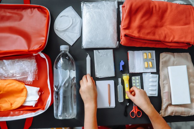 Close-up of women's hands putting a survival kit together.
