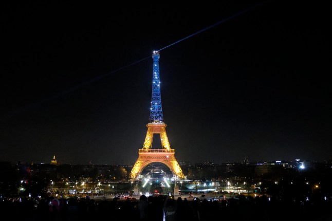 This photograph shows the Eiffel Tower lit up in the colors of the Ukrainian flag in Paris on March 26, 2025, on the eve of a summit with the 'coalition of the willing'. Ukraine's President Volodymyr Zelensky meets with French President Emmanuel Macron on mrach 26, 2025, ahead of the March 27 gathering of leaders from the so-called "coalition of the willing" -- a British-French led group of countries considering deploying peacekeeping troops to Ukraine should a ceasefire be reached. (Photo by Ludovic MARIN / AFP) (Photo by LUDOVIC MARIN/AFP via Getty Images)