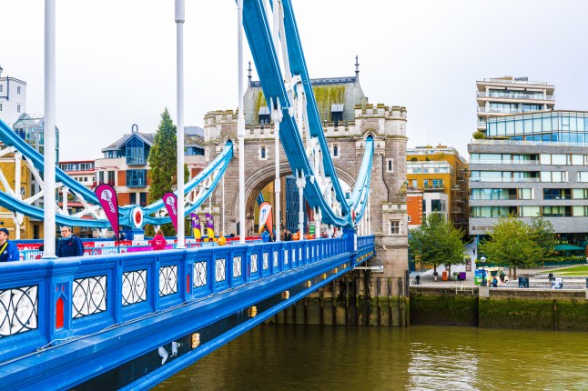 Tower Bridge lined with people and banners for the London Marathon.
