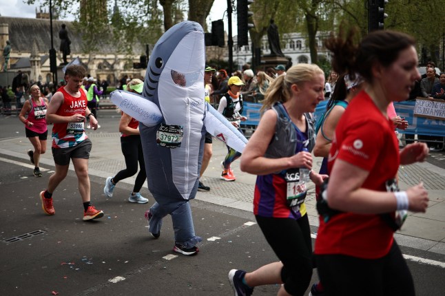 Fun runners, one dressed as a shark, compete in the 2024 London Marathon in central London on April 21, 2024.