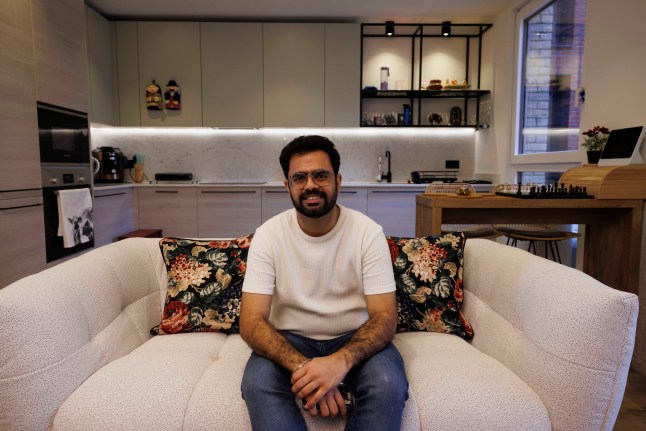 What I Own - Poplar. Nitish Kumar. Pictured: Nitish on the living room couch, open kitchen behind. Image shot on 4th April 2025. ?? Belinda Jiao jiao.bilin@gmail.com 07598931257 https://www.belindajiao.com/about