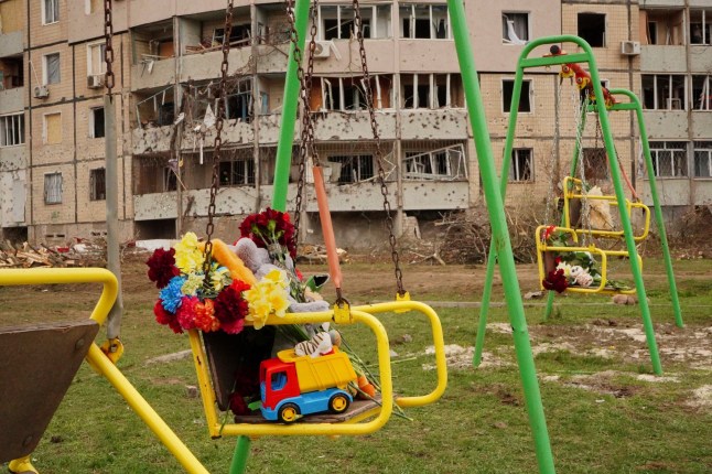 Flowers and toys left on a swing seat to commemorate victims killed in Russia's missile attack on Friday, at a children play area near the damaged apartment buildings, in Kryvyi Rih, Ukraine, Saturday, April 5, 2025. (AP Photo)