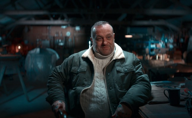 Lee Wenham speaking in Netflix documentary The Diamond Heist. He is wearing a cream cableknit jumper and khaki jacket.