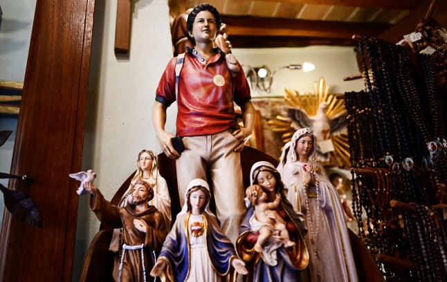 Figurines of Blessed Carlo Acutis, an adolescent who spent his life spreading his faith online, earning the moniker "God's Influencer", are on sale in a souvenirs shop in Assisi where Acutis is on display, on April 3, 2025. Blessed Carlo Acutis, the world's first millennial saint who died in 2006 aged 15, will be canonized by Pope Francis on April 27, 2025 in The Vatican. (Photo by Tiziana FABI / AFP) (Photo by TIZIANA FABI/AFP via Getty Images)