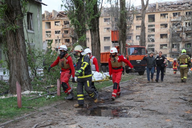 Paramedics and a rescuer carry the body of a person found under debris of an apartment building hit by a Russian missile strike, amid Russia's attack on Ukraine, in Kyiv, Ukraine April 24, 2025. REUTERS/Ivan Antypenko