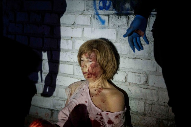 An injured woman sits near her house, which was damaged by a Russian airstrike, in a residential neighbourhood in Kyiv, Ukraine, on Thursday, April 24, 2025. (AP Photo/Evgeniy Maloletka)