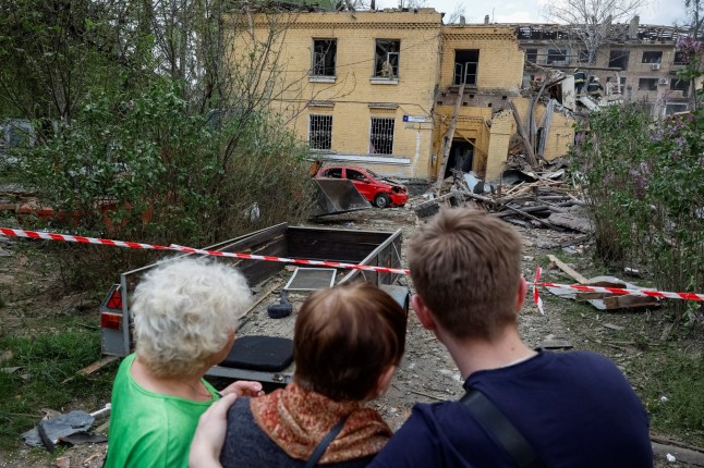 Residents wait for results of a rescue operation at the site of a residential building damaged during a Russian missile strike, amid Russia's attack on Ukraine, in Kyiv, Ukraine April 24, 2025. REUTERS/Alina Smutko