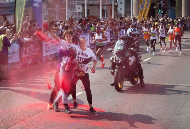 ? Licensed to London News Pictures. 27/04/2025. London, UK. Youth Demand activists throw red powder as the men's Elite runners reach Tower Bridge during the London Marathon. Over 56,000 elite, fun and charitable runners tackle the 26. 2 miles across London, raising millions of pounds for charity. Photo credit: Peter Macdiarmid/LNP